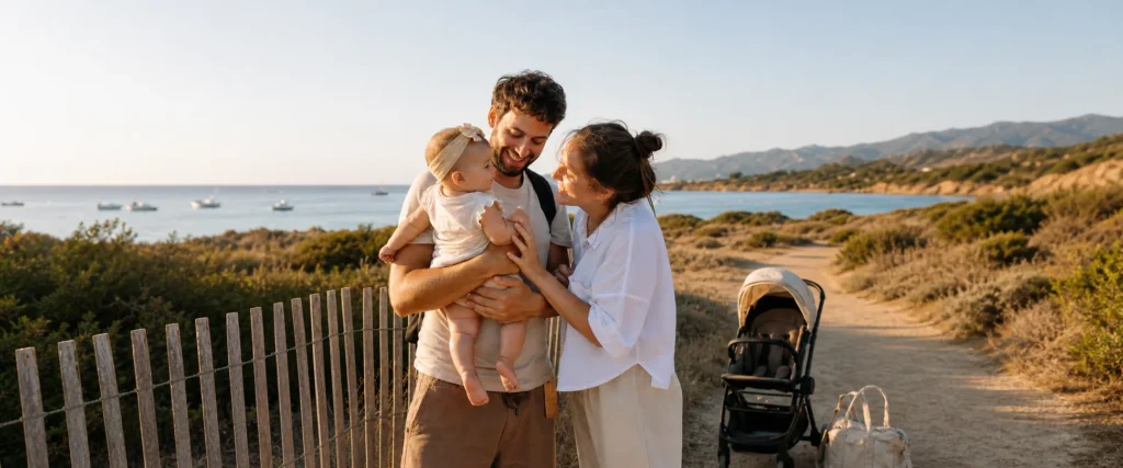 Parents et bébé en vacances au bord de la mer avec une poussette